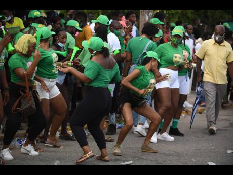 Scores of political supporters threw caution to the wind as they danced in the street on Olympic Way in the vicinity of the Olympic Gardens Civic Centre in St Andrew yesterday.
