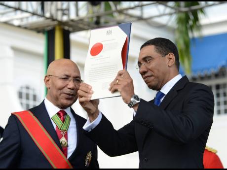 File 
Governor General Sir Patrick Allen looks on as Prime Minister Andrew Holness holds aloft the instrument of appointment at his swearing in ceremony at King’s House on March 3, 2016.