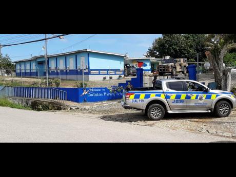 Police and soldiers maintain a security presence at Darliston Primary School where ballots were being recounted for the Westmoreland Eastern constituency. Luther Buchanan won by a single vote cast by the returning officer.