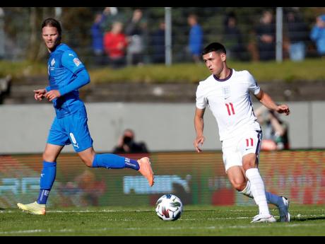 England’s Phil Foden (right) runs with the ball during the UEFA Nations League match against Iceland in Reykjavik, Iceland, on Saturday, September 5. Both Foden and his teammate, Mason Greenwood, have been dropped for today’s game against Denmark after