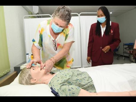 Professor Denise Eldemire-Shearer, director of the Mona Ageing and Wellness Centre at The University of the West Indies, examines a medical mannequin as Beverley Dinham Spencer, principal of Strategic Management and Training Consultants Ltd Career Institut
