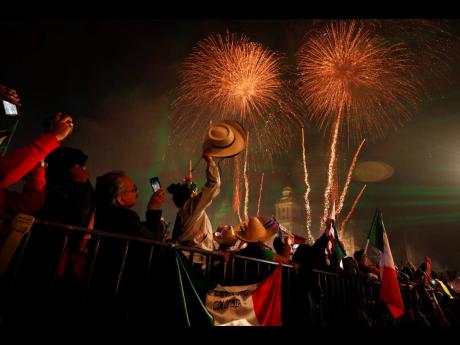 
MAIN PHOTO: Revellers celebrate as fireworks explode over the Metropolitan Cathedral after President Andres Manuel Lopez Obrador gave the annual independence shout from the balcony of the National Palace to kick off Independence Day celebrations in Mexico