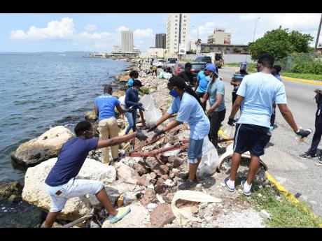 Volunteers participating in an impromptu clean-up last Saturday along a section of the Kingston Harbour.
