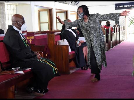 Michelle Salmon dances in front of Chief Justice Bryan Sykes during the annual assize service at Webster Memorial United Church in Kingston on Sunday.