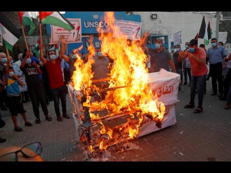 Palestinians burn mock coffins representing the United Arab Emirates and Bahraini normalisation agreements with Israel. This is during a protest in front of the office of the United Nations Special Coordinator for the Middle East Peace Process in Gaza City