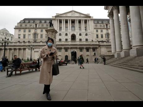 
A pedestrian in face mask walks past the Bank of England in London, on Wednesday, March 11, 2020.