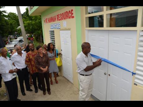 Hanover Eastern Member of Parliament Dr D.K. Duncan (second left) and other officials look on as community member John Whyte cuts the ribbon to signal the official opening of the Mount Hannah Resource Centre in Hanover, which was established at a cost of a