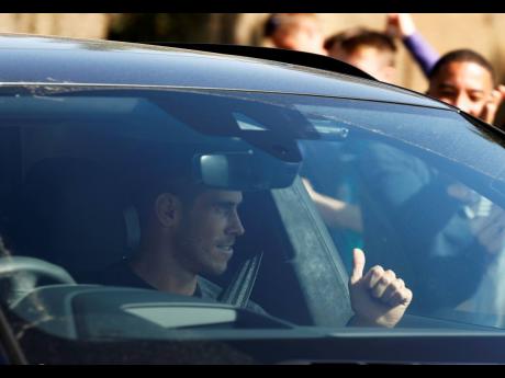 Footballer Gareth Bale gestures to fans as he arrives at the training ground of Tottenham Hotspur in London, England, yesterday.