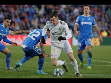 Real Madrid’s Gareth Bale (centre) dribbles through the defence during a Spanish LaLiga match against Getafe at the Coliseum Alfonso Perez in Getafe, Spain, on Saturday, January 4.