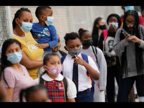 Students wear protective masks as they arrive for classes at the Immaculate Conception School while observing COVID-19 prevention protocols in The Bronx borough of New York.