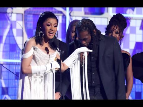 Cardi B, left, accepts the award for best rap album for “Invasion of Privacy” as Offset kisses her hand at the 61st annual Grammy Awards.