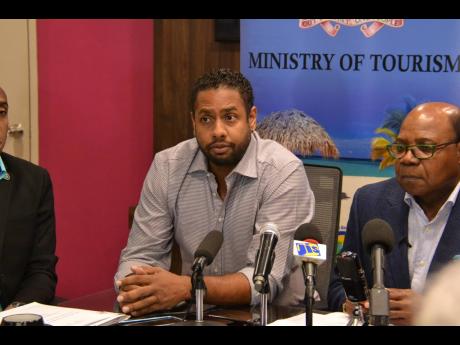 Kamal Bankay (left), chairman of the Carnival in Jamaica stakeholders committee, sitting alongside Edmund Bartlett, minister of tourism, at press conference COVID in March. ??