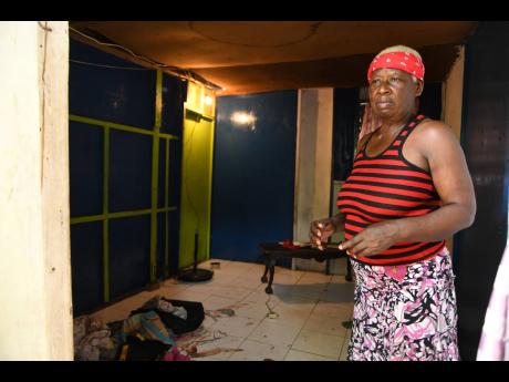 Patricia Shaw is a picture of pain as she stands in the room where her daughter, Nichola Pink, was shot dead in Denham Town, Kingston, on Sunday. Two others were slain in the Chestnut Lane gun attack. 