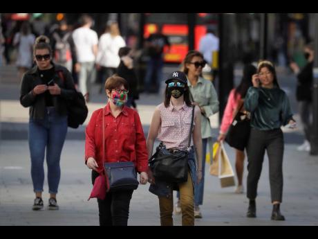 Shoppers wear masks on Oxford Street in London yesterday. Britain’s top medical advisers have painted a grim picture of exponential growth in illness and death if nothing is done to control the second wave of coronavirus infections, laying the groundwork