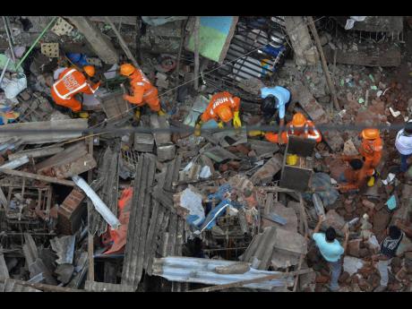 Rescuers look for survivors after a residential building collapsed in Bhiwandi in Thane district, a suburb of Mumbai, India, yesterday. 