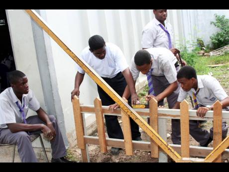 In this 2007 Gleaner photo, woodwork teacher Lloycent Gordon checks if a fence his students are working on is level during class at Ascot High School in Portmore, St Catherine.