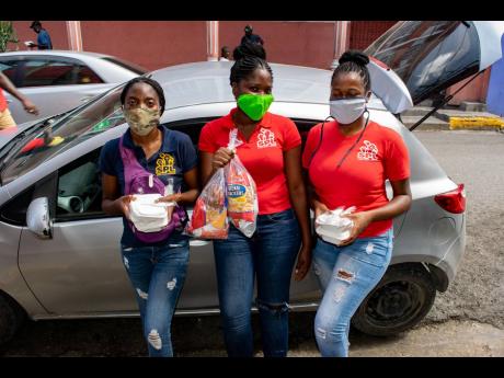 Street People Liberation volunteers (from left) Masani Anderson, project coordinator; Shantoya Grant, project manager; and  Jessica Robinson, project coordinator, don masks as they participate in a May outreach event. The size of the team engaged in each p
