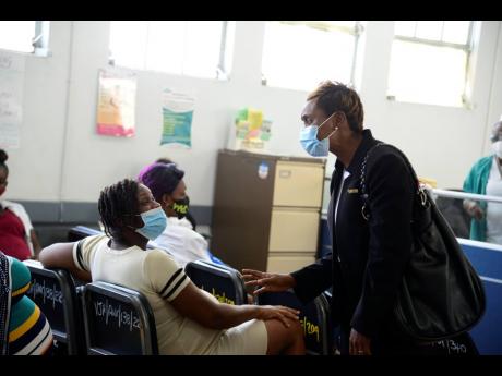 State Minister in the Ministry of Health & Wellness Juliet Cuthbert Flynn interacts with patients while touring the Victoria Jubilee Hospital in Kingston yesterday.
