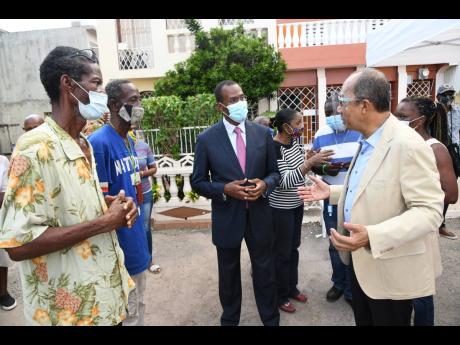Horace Chang, (right)  minister of national security, and Nigel Clarke (second right), minister of finance,  speak with residents of the Gendale Housing community during their visit to Pembroke Hall/Hughenden/Glendale communities with the Jamaica Constabul