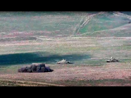 In this image taken from a footage released by Armenian Defence Ministry on Sunday, September 27, 2020, Armenian army destroys Azerbaijani tanks at the contact line of the self-proclaimed Republic of Nagorno-Karabakh, Azerbaijan. 