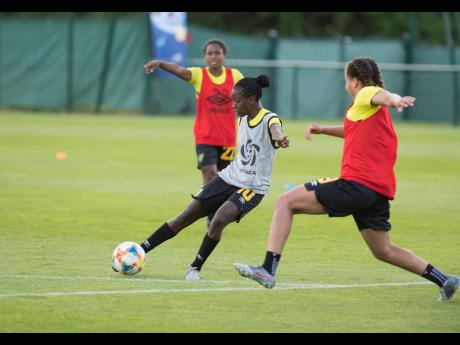 Jamaica’s Mireya Grey looks on as teammate Jody Brown (centre) takes a shot, with Toriana Patterson attempting to block, during a team training session at the FIFA Women’s World Cup in France on Monday, June 10, 2019.