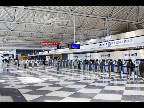 In this June 25, 2020 file photo, rows of United Airlines check-in counters at O’Hare International Airport in Chicago are unoccupied amid the coronavirus pandemic. About 40,000 workers in the airline industry are facing lay-offs as of Thursday, October 