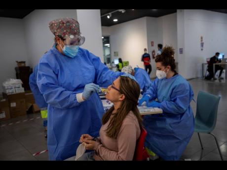 Madrid Emergency Service health workers conduct rapid antigen tests for COVID-19 in the southern neighbourhood of Vallecas in Spain on Tuesday. Madrid has a rate of infection 2.5 times higher than the national average, which is already three times the Euro