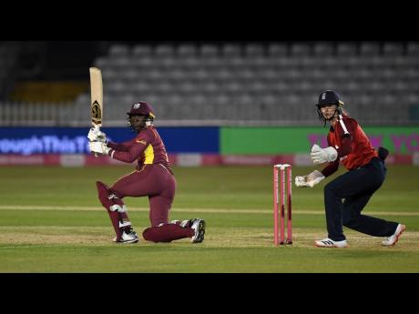 Stafanie Taylor (left) of the West Indies plays a shot while England wicketkeeper Amy Jones looks on during the first Vitality Twenty20 International match at the Incora County Ground in Derby, England, on September 21.