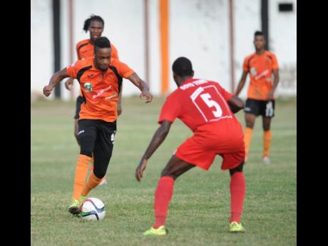 In this file photo from November 2015, Junior Flemmings (left), then representing Tivoli Gardens FC, takes on Boys Town’s Rupert Murray during a National Premier League game at the Edward Seaga Sports Complex.