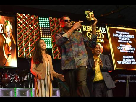 Winston ‘Wee Pow’ Powell of Stone Love, walks away with his trophy after he was acknowledged at Wednesday’s Reggae Gold Awards at the National Indoor Sports Centre.