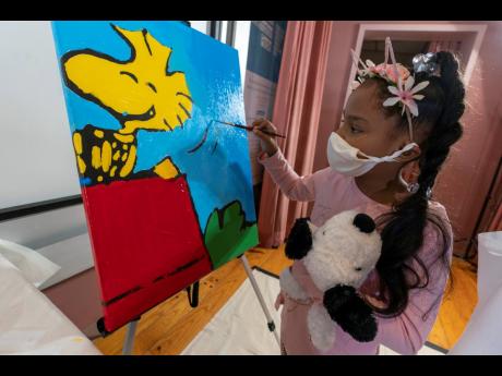 
Kaley Williams, eight, paints a panel of a “Peanuts” mural that will be placed in the outpatient paediatric floor of One Brooklyn Health at Brookdale Hospital, Thursday, October 1, 2020, in the Brooklyn borough of New York. 