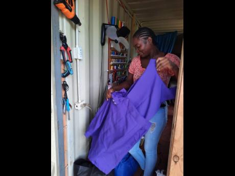 Nathalie Jordan displays uncollected school uniforms left at her shop by parents as schools open online tomorrow. She explained that business has been slow this year as not all schools require that students wear uniforms during online classes.
