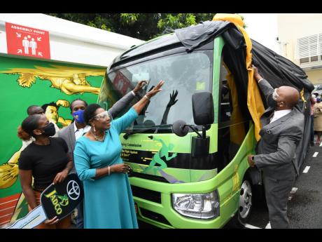 Jamaica Anti-Doping Commission (JADCO) Chairman Alexander Williams (right), Sports Minister Olivia Grange (second right), athlete Megan Tapper (left) and State Minister for Sports Alando Terrelonge unveil an anti-doping mobile unit given to JADCO by the sp
