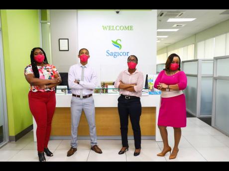 RIGHT: Team members from Sagicor Investments, Dominica Drive in Kingston, pose in their pink masks.