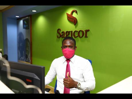 Dominique Smith is the pleasant face that greets clients at the client services centre at the R. Danny Williams Building in New Kingston. He is ‘repping’ in his pink mask and pink tie.