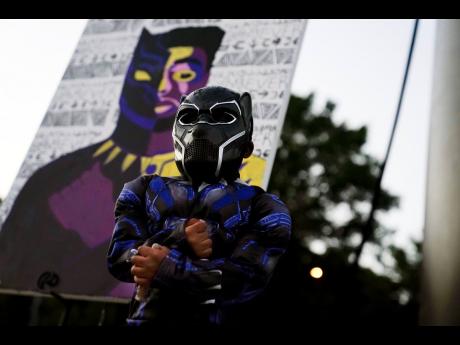 AP
Mason Wilkes, 4, of South Carolina, poses for his father in a Black Panther costume, in front of a painting during a Chadwick Boseman Tribute on Thursday, September 3, 2020, in Anderson, South Carolina. 