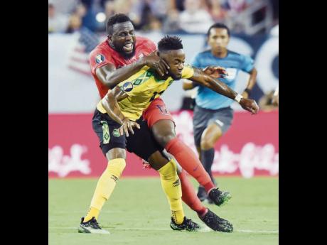Jamaica forward Junior Flemmings (foreground) comes under a challenge from United States forward Jozy Altidore during a Concacaf Gold Cup semi-final football match in Nashville, Tennessee, on July 3, 2019. 
