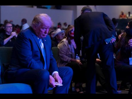 President Donald Trump prepares his offering as he attends church at International Church of Las Vegas on Sunday in Las Vegas, Nevada. AP