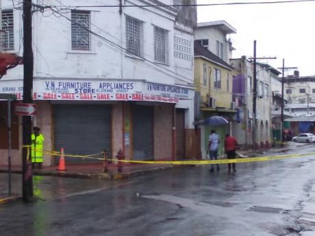 Police investigators at a crime scene along Strand Street in downtown Montego Bay, where Melaki Walters was chased and shot dead by gunmen yesterday.