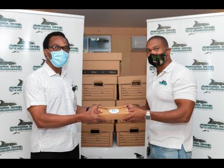 Dr Stuart Murray (left), senior medical officer (deputised), Spanish Town Hospital, accepts a box of food from Dwayne Neil, assistant vice-president, Personal Financial Planning, Sterling Asset Management.