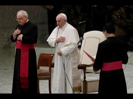 Pope Francis makes the sign of the cross during his weekly general audience in the Paul VI Hall at the Vatican yesterday. 