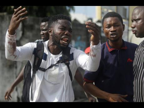 Alister, a protester who says his brother Emeka died from a stray bullet from the Army, reacts while speaking to AP near Lekki toll gate in Lagos, Nigeria, on Tuesday.
