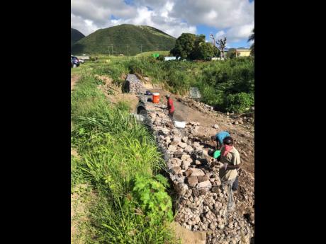 Work crews installing gabion baskets at the  College Street Ghaut in St Kitts in March 2020.