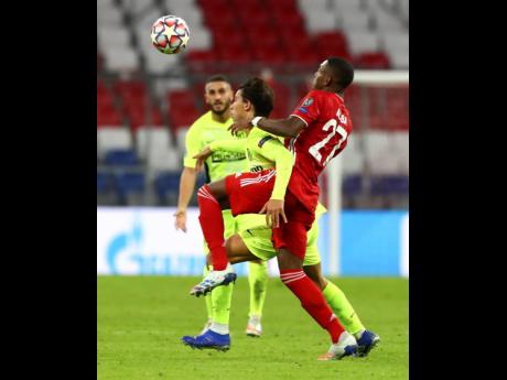 Bayern Munich’s David Alaba (right) and Atletico Madrid’s Joao Felix battle for the ball during the Champions League Group A match between Bayern Munich and Atletico Madrid at the Allianz Arena in Munich, Germany, yesterday. Bayern won 4-0.