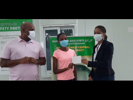 Whitney Williston, a second-year management student at the University of the West Indies, Mona, Western Jamaica campus, accepts a cheque from Marlene Malahoo-Forte (right) while Dwight Crawford, left), councillor for the Spring Gardens division, looks on. 