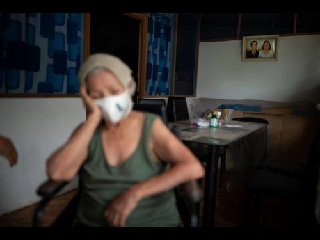 Suffering from a high fever related to dengue, 72-year-old Luz Rengifo rests inside her home in Pucallpa, Peru, on Tuesday.