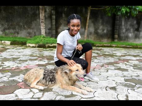 In this photo taken on Wednesday, October 14, 2020, Dodeye Ewa, 16 years old, plays with a dog outside her compound in Calabar, Nigeria. The third child is bothered by President Donald Trump’s rhetoric and his policies towards international students, mos