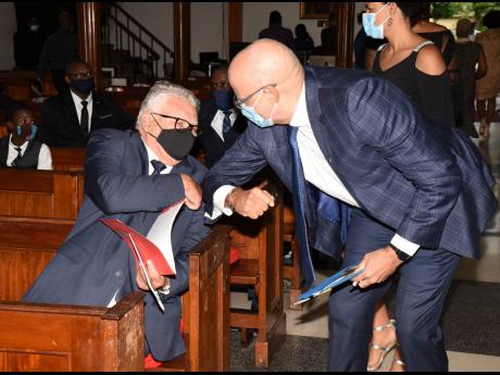 Minister of Labour and Social Security Karl Samuda (left), who participated in the service on  behalf of the prime minister, greets Keith Duncan. Duncan, who spoke on behalf of his siblings, said at the service that his father was an example for the entire