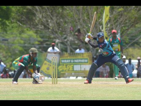Johnson Mountain batsman Jair Campbell (right) steadies himself for a shot while Gayle wicketkeeper Anthony Walters looks on during their Social Development Commission Wray & Nephew Community Twenty20 Cricket competition at the Ultimate Cricket Oval in St 