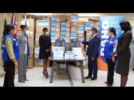 UK High Commissioner Asif Ahmad (third right), makes a point to State Minister of Health and Wellness Juliet Cuthbert-Flynn (third left), at yesterday’s multi-partner donation of more than 80,000 antigen rapid diagnostic COVID-19 tests. Sharing the momen